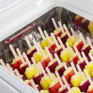 vitrine de exposição que contém gelados artesanais de cor vermelha e amarela. O seu modelo é um ICE3, com exterior branco, e interior em inox. Os gelados estão expostos de forma vertical e estão facilmente acessíveis a qualquer pessoa para retirar sem tocar noutro gelado.